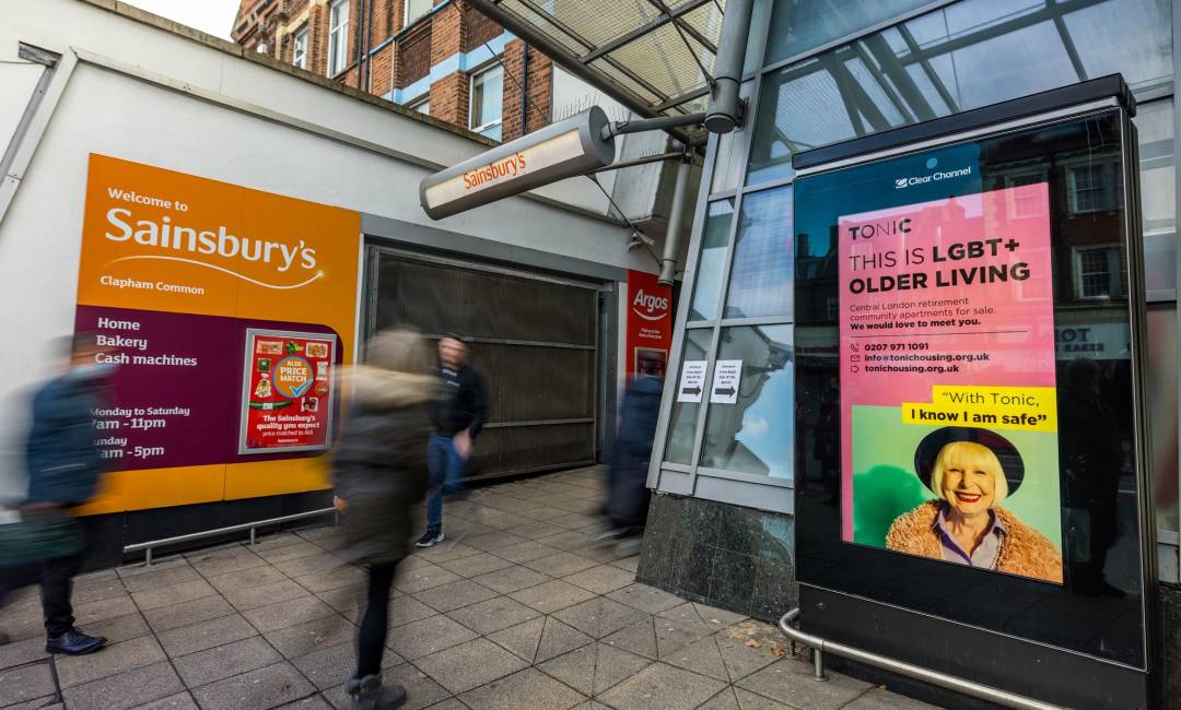 Adshel screen outside shopping mall as people walk by