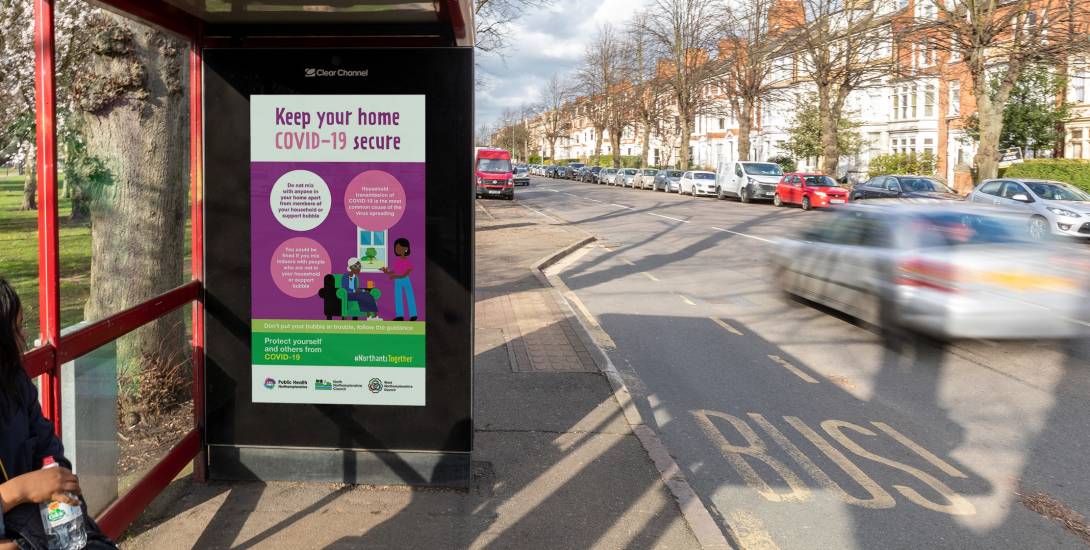 Digital screen on a bus stop showing Covid info from West Northamptonsire Council