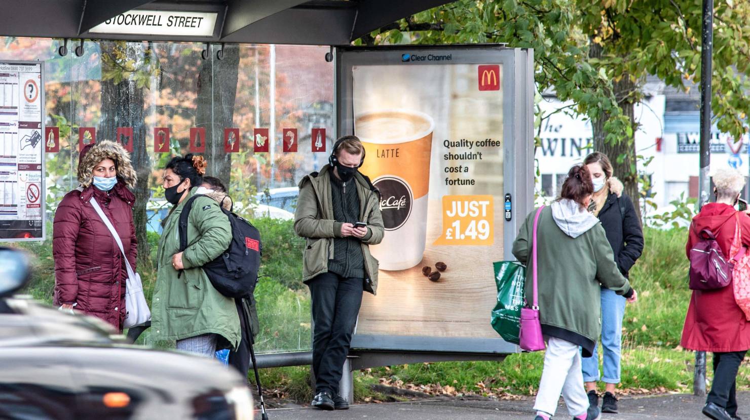 McDonalds bus shelter poster in Glasgow with people waiting for the bus