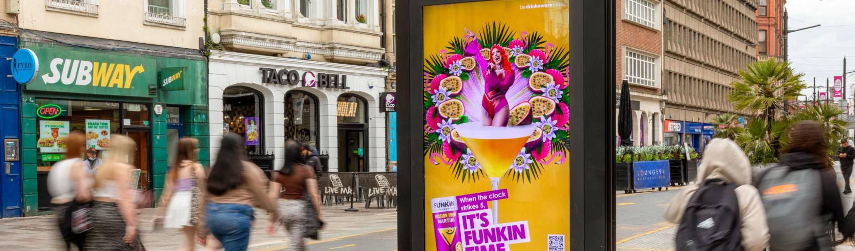 A  bright orange and pink 'Funkin Cocktail' ad campaign featuring on a Clear Channel Adshel Live screen