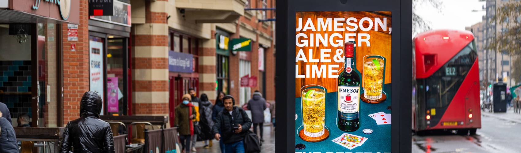 Whiskey advert on a digital poster on a high street in the rain