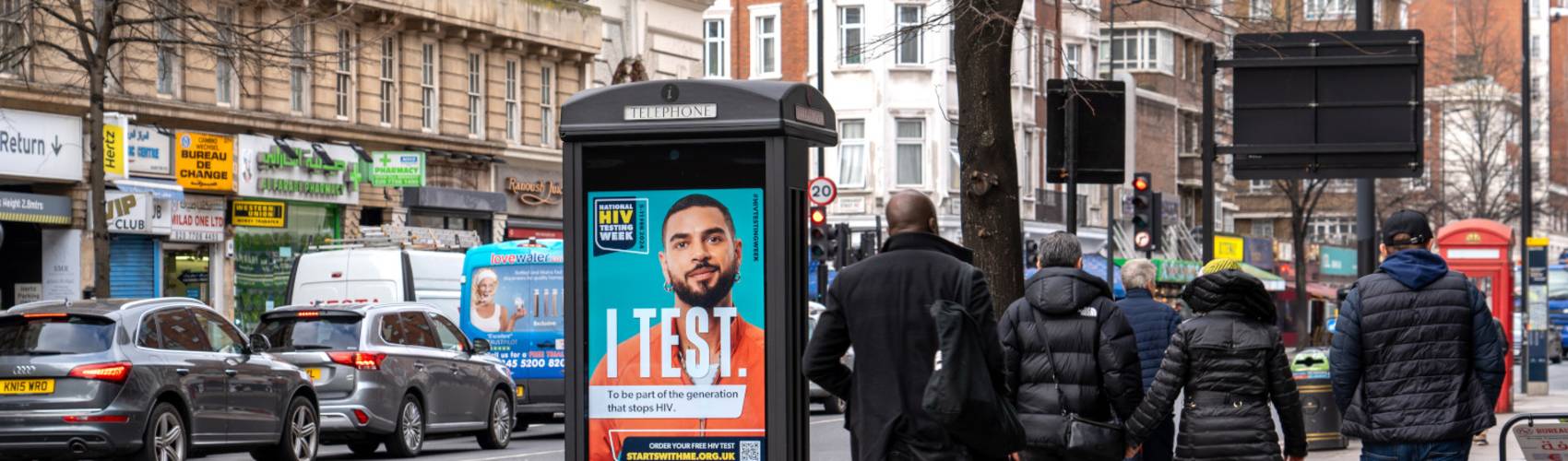 An 'I Test' campaign displaying on an Adshel Live screen on a busy high street