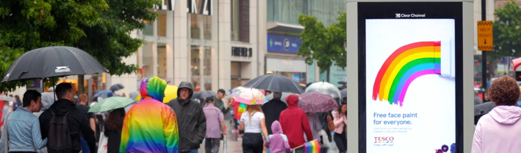 Tesco Pride advertisement on Adshel Live in a busy square