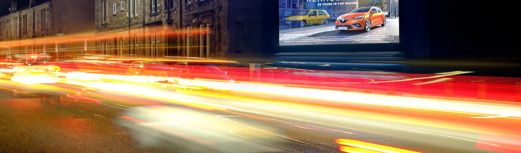 Night time shot of digital billboard advertising screen displaying Renault Clio advert