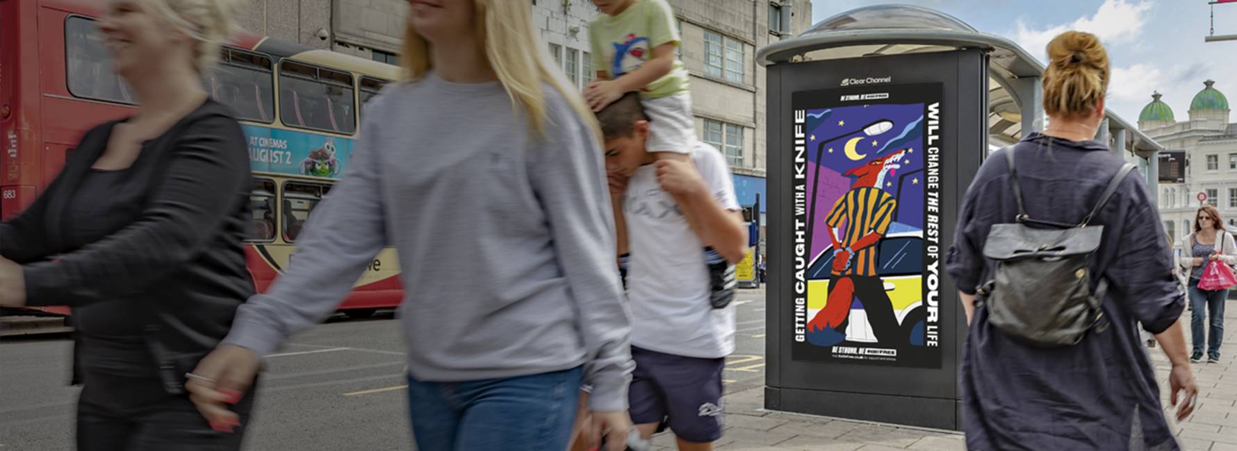 An Adshel Live digital screen with people walking past