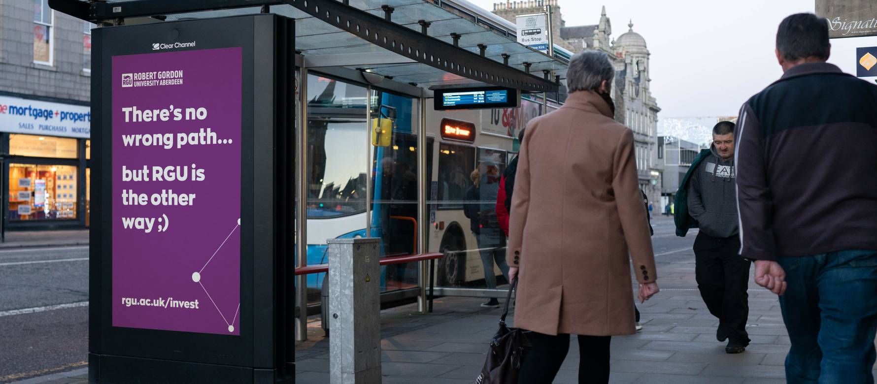 Adshel live screen on a bus stop showing Robert Gordon University advert