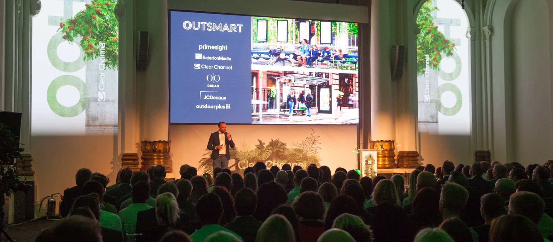 A person standing in front of a large screen and presenting.