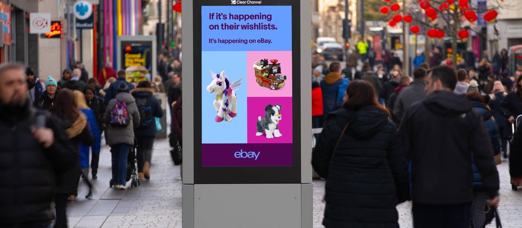 Digital screen showing an ebay advert with toys on a busy high street