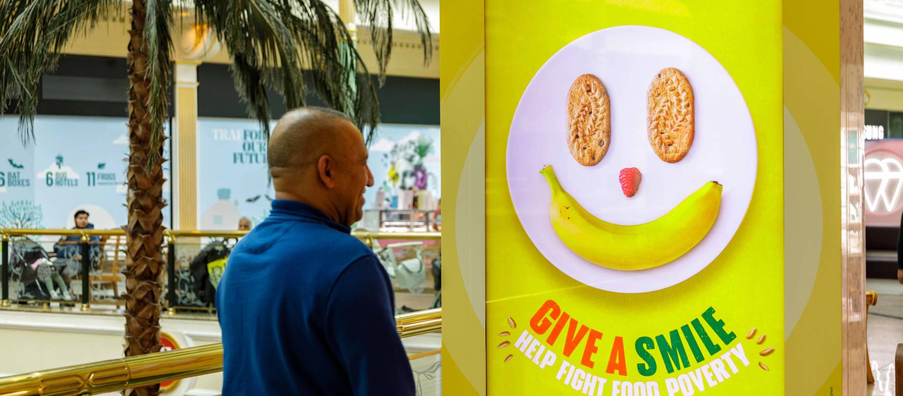 Man smiling at Belvita: Give a smile campaign on Out of Home screen