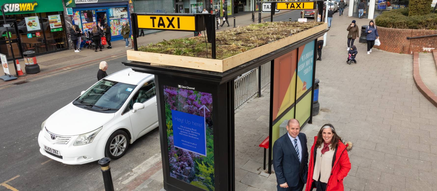 Clear Channel's, Chris Mclelland, and Worthing Council's, Vicki Wells, during the day, standing in front of a brand new taxi shelter with a Living Roof on top