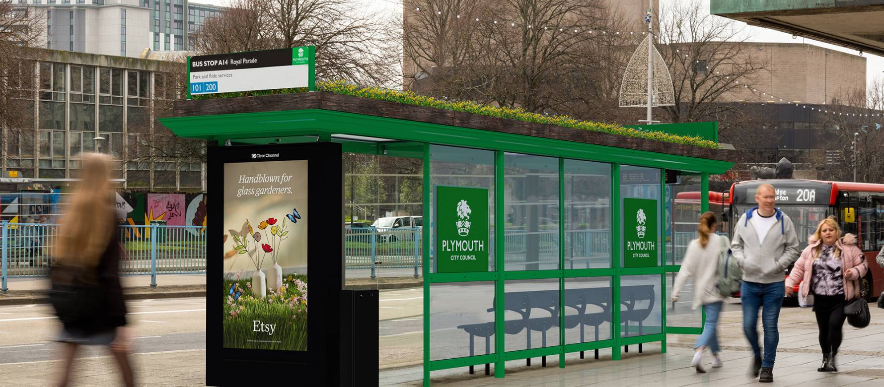 A living roof bus stop with people walking on the sidewalk.