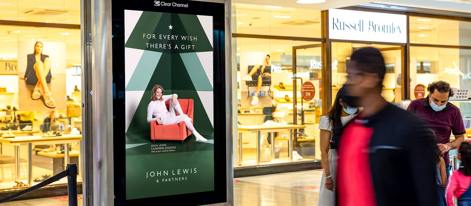 Digital screen in a shopping mall outside Russell & Bromley showing a John Lewis advert