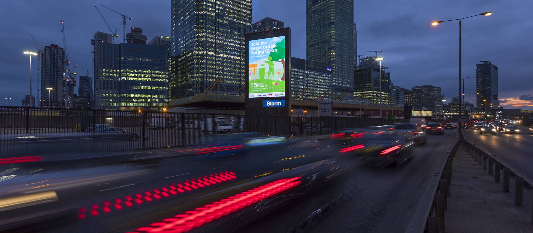 An advert for Keep Britain Tidy's Great British Spring Clean on a Storm billboard in Billingsgate, as cars drive past during the evening
