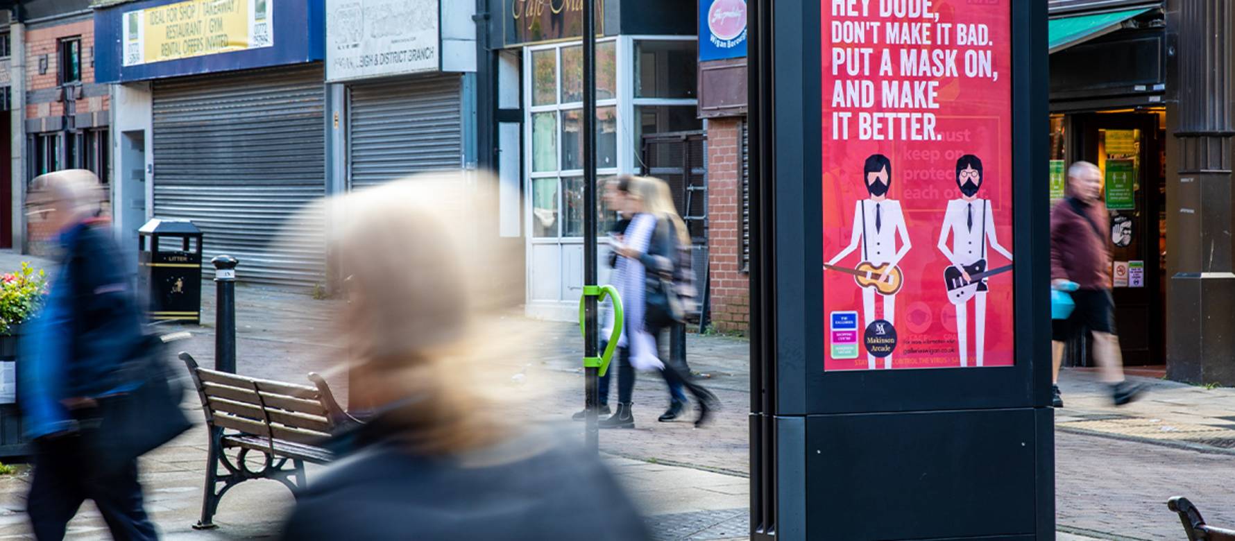 A Covid-19 related campaign on Adshel Live screen on a high street