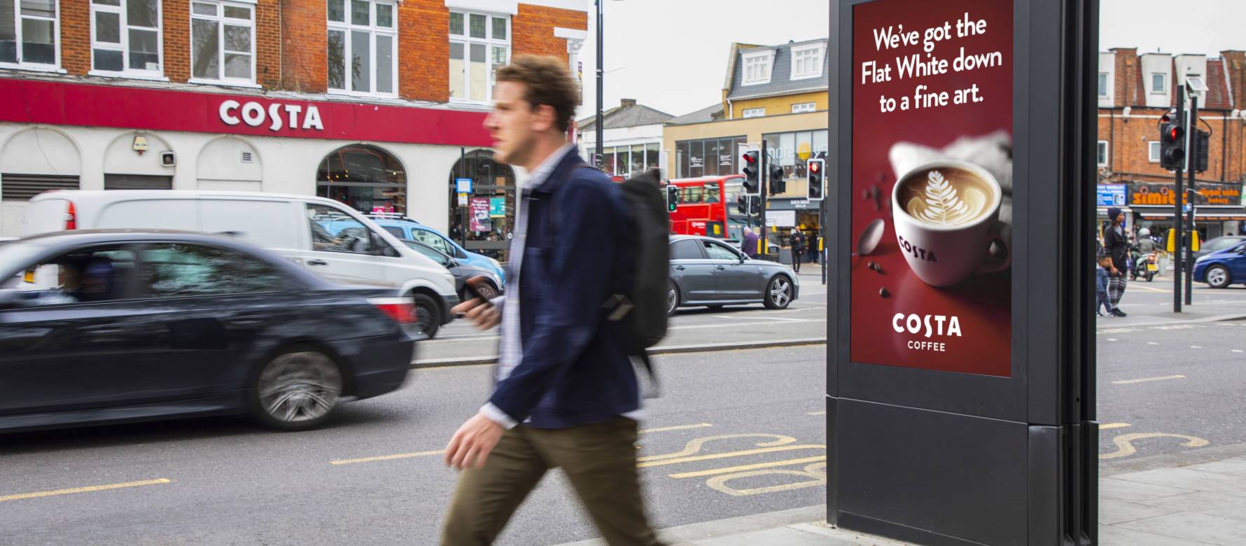 Digital screen on a busy high street showing Costa Coffee advert