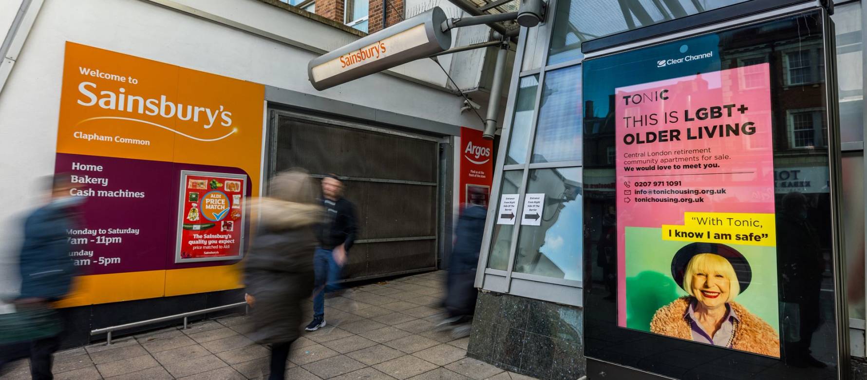 Adshel screen outside shopping mall as people walk by