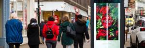 Valentines digital poster of red roses on a high street phonebox with three women walking past