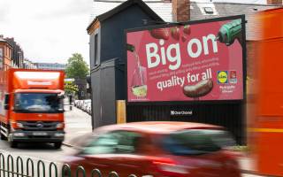 Lidl's pink Billboard Live 'Big on quality for all' advertisement with motor vehicles driving past