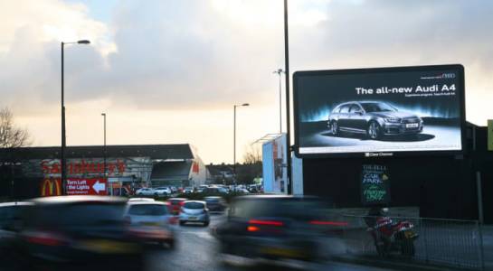 An Audi ad on a digital billboard on a busy road