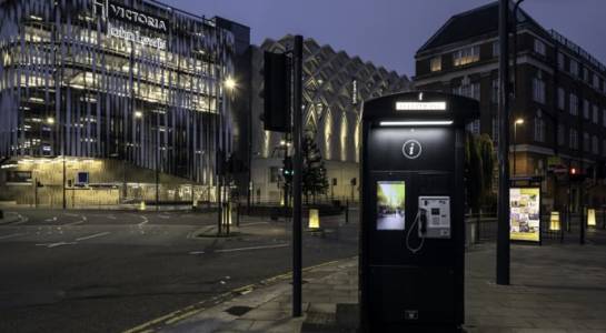 A phone kiosk on a high street at night