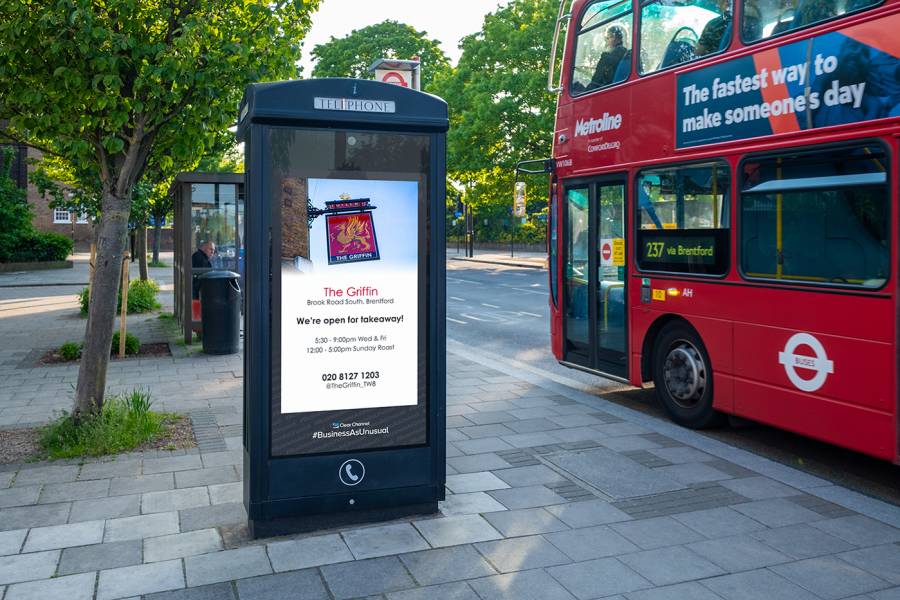Adshel free-standing screen beside red bus displays pub sign image
