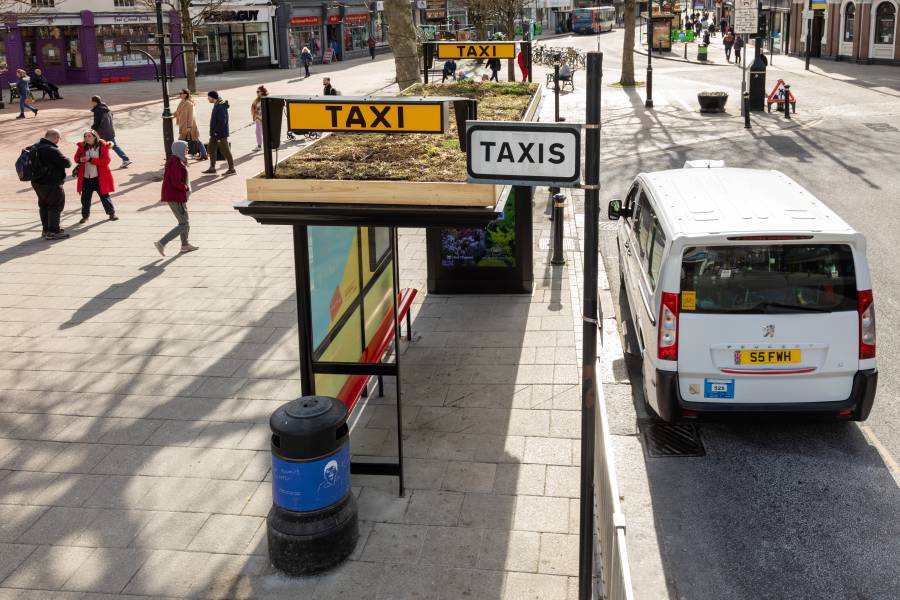 A new taxi shelter with a Living Roof on top located by a busy square