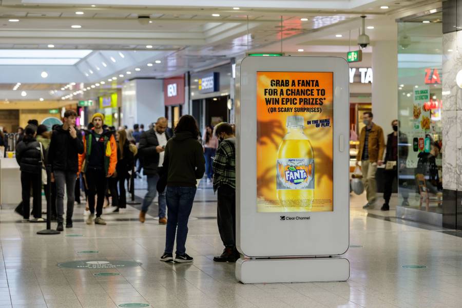 Digital screen in a busy shopping mall showing Fanta advert