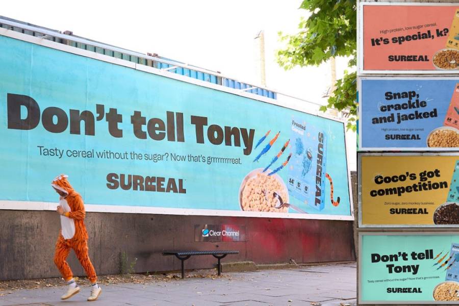 Multiple posters for Surreal cereal campaign with one of them displayed on a paper billboard with a person dressed up as a tiger in front of it