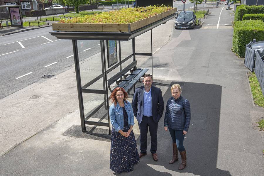 Clear Channel staff and Derby council staff standing next to a living roof