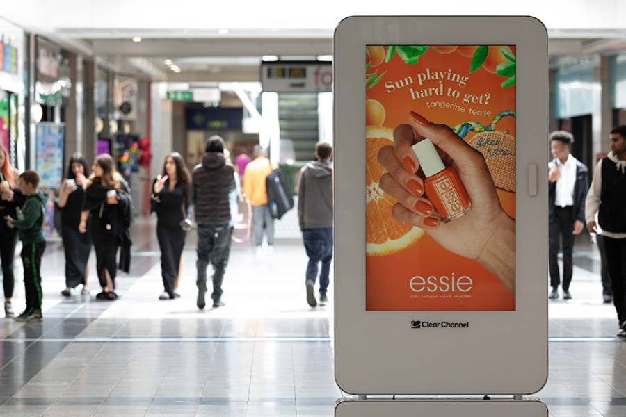 Digital screen in a busy shopping mall showing Essie advert