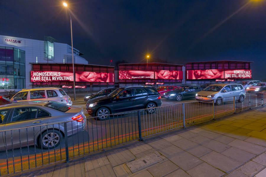 Storm Cromination site at night showing 'Still Revolting' artwork by Clear Channel Artist in residence Martin Firrell