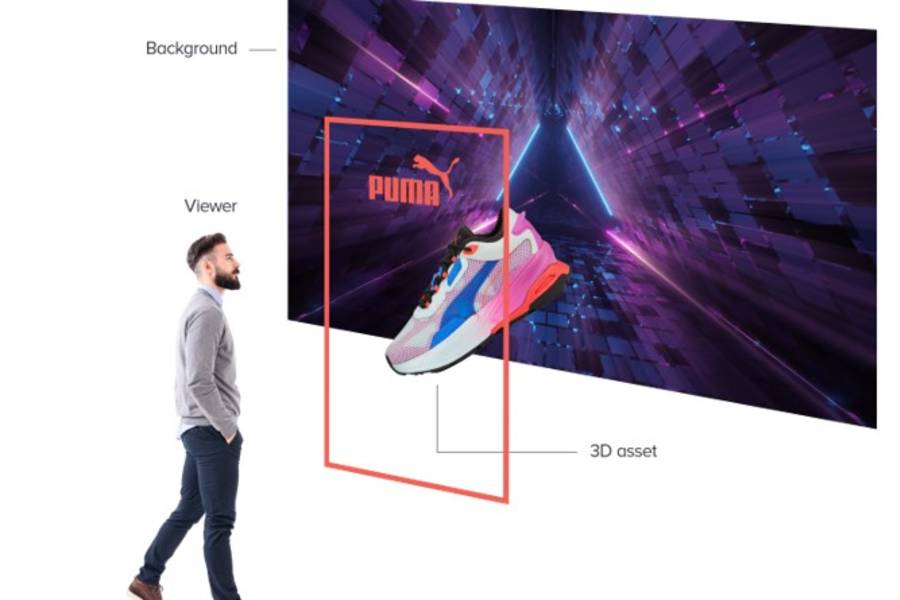 A man looking at a large screen displaying a 'Puma' trainer