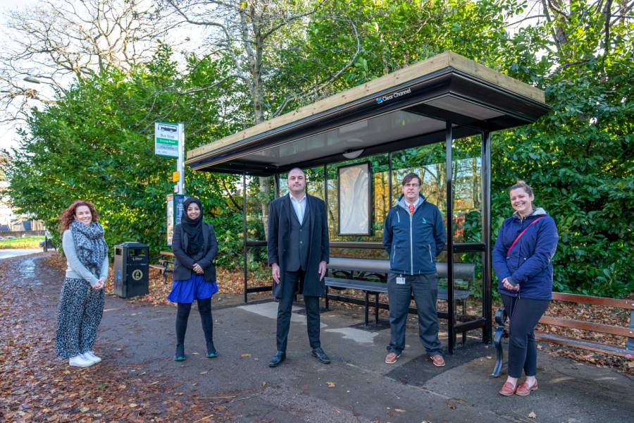 Local councillors and Clear Channel representatives standing in front of a bus shelter with a living roof in Oxford