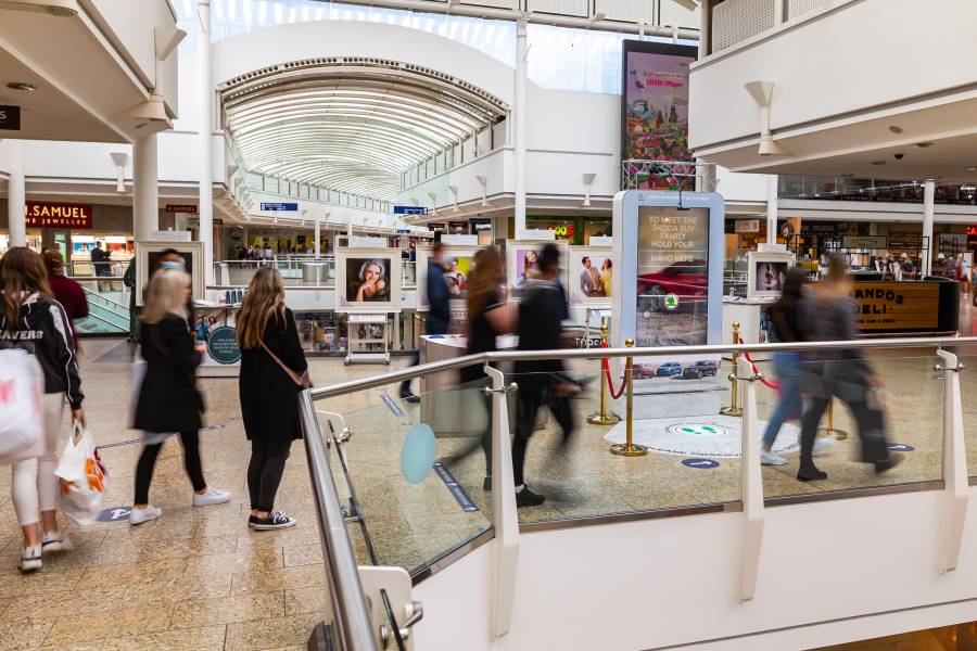 Digital screen in a busy shopping mall near H Samuel showing Skoda advert