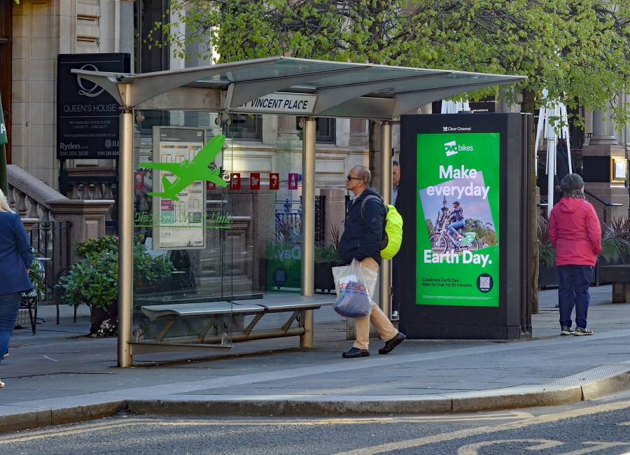 A bus shelter in St Vincent with people walking around.