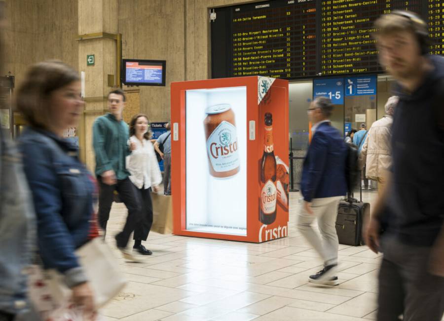 A 3D Cristal advertisement in a busy train station as individuals walk by