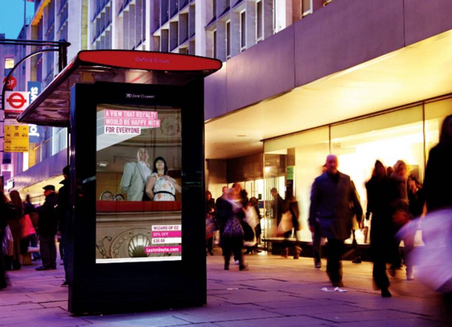 Clear channel digital screen on a bus stop showing ad for lastminute.com