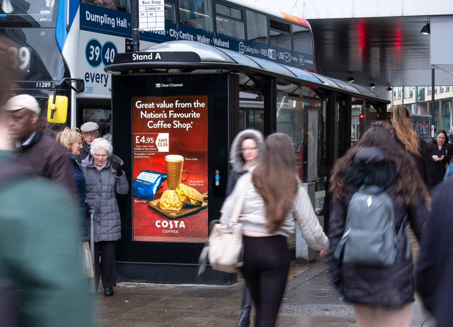 Digital screen on a bus stop showing advert for Costa Coffee on a busy high street