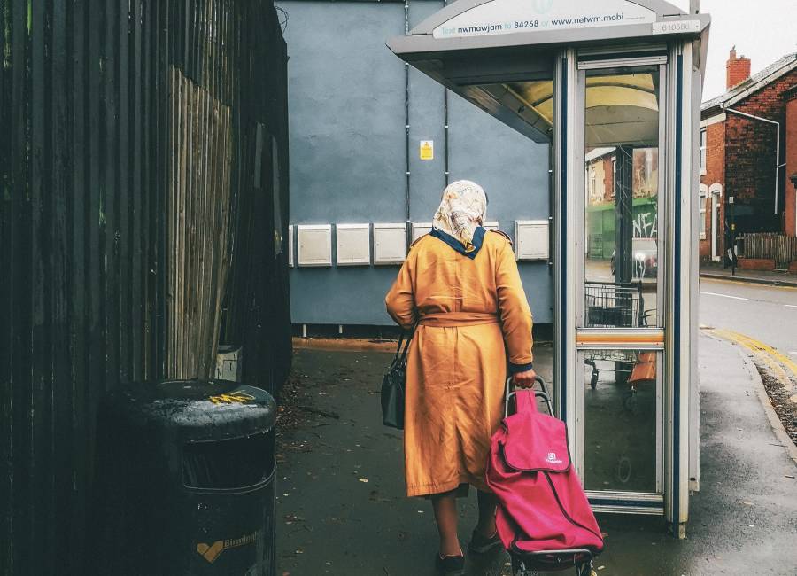 A woman walking to a bus shelter