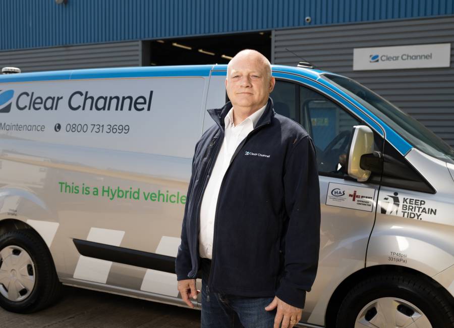 One of our operatives standing next to a Ford hybrid vehicle.