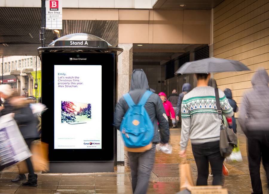 Digital screen on a bus stop showing Currys Pc World ad