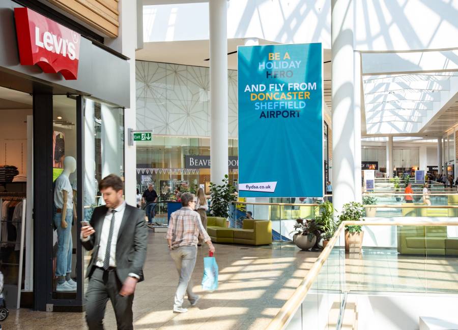 A large digital screen in Sheffield Meadow Hall next to Levi's store