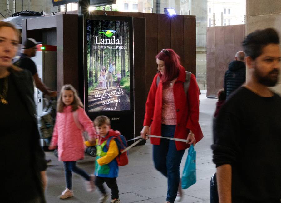 A women and children walking past our Adshel live screens.