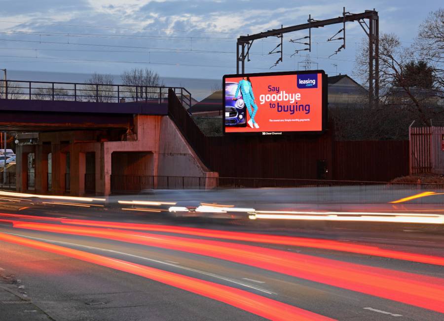 Leasing.com advert on a Billboard Live screen next to passing traffic