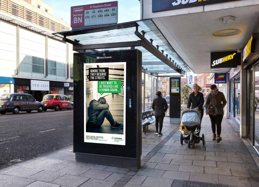 St Martins Bus Shelter ad as people walk past