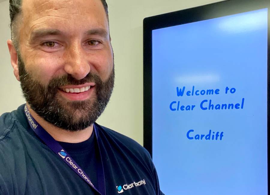 Rhys Murphy, Digital Technician at Clear Channel UK, in front of a digital screen in Cardiff depot