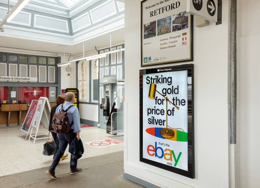 Rail station concourse with Clear Channel billboard showing Ebay ad