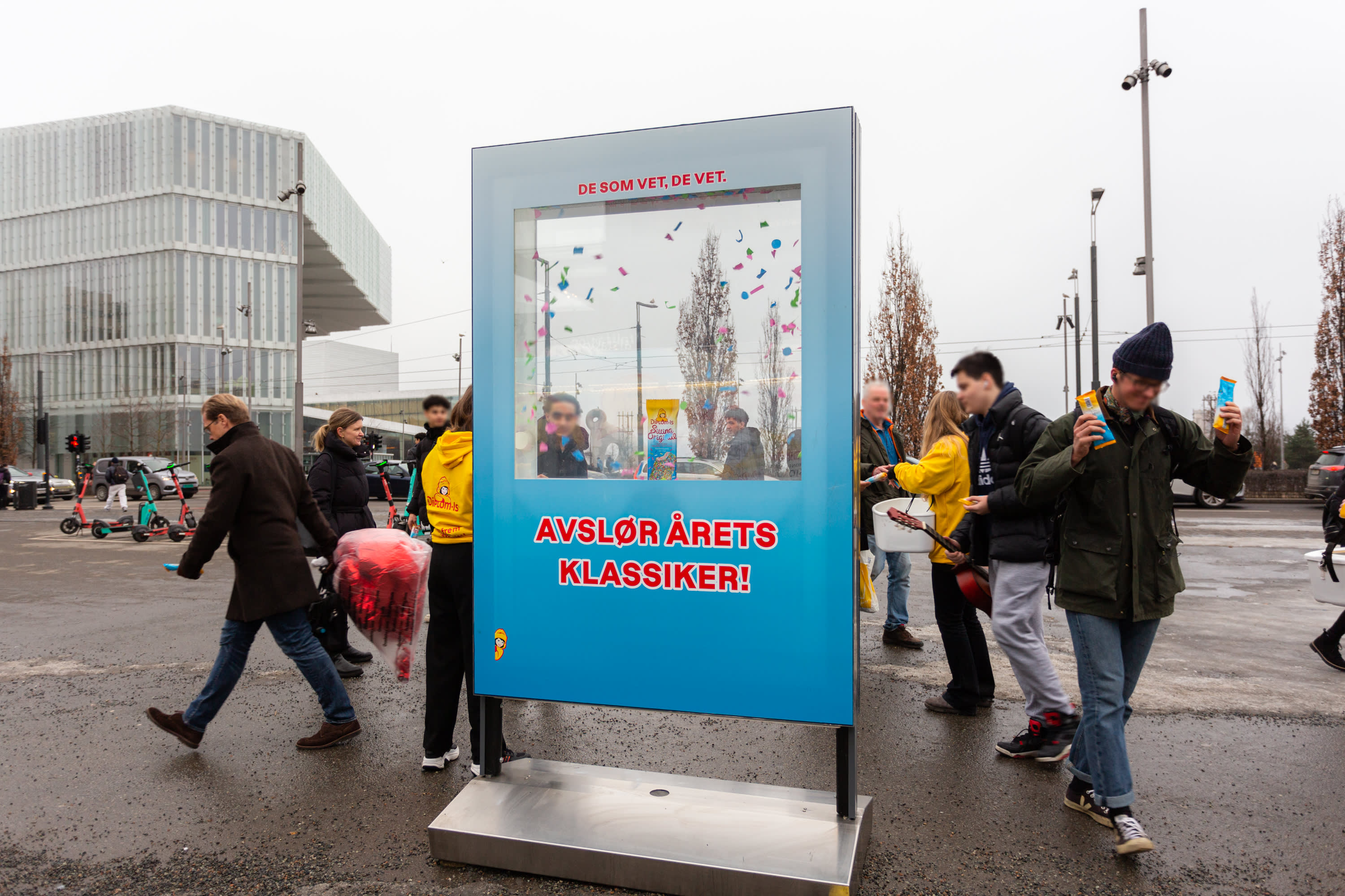 People smiling and getting sweets from an interactive advertisement