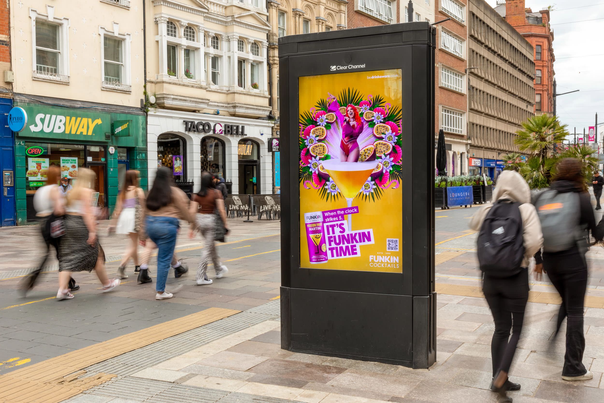 A  bright orange and pink 'Funkin Cocktail' ad campaign featuring on a Clear Channel Adshel Live screen