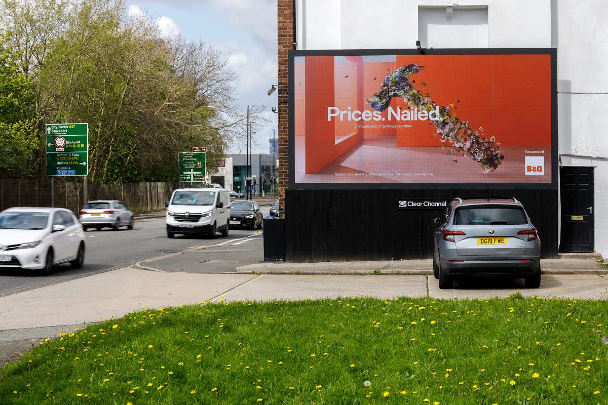 Clear Channel billboard live screen showing B&Q ad on a busy road